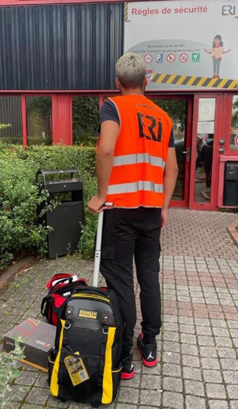 Photo d'une personne qui transporte un sac à dos à roulettes pour ses outils - © ERI